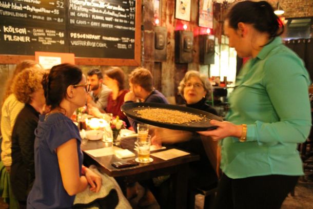 Bertha Jimenez holds a tray of grain used in the brewing process.