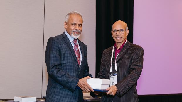 Sreenivasan standing with Dr. Muhammed Taher Saif, holding prize