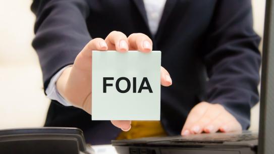 hand holding card that reads "FOIA"