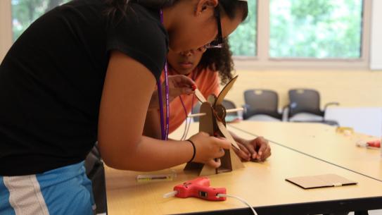 Two Science of Smart Cities students create a working windmill to implement in their model city. 