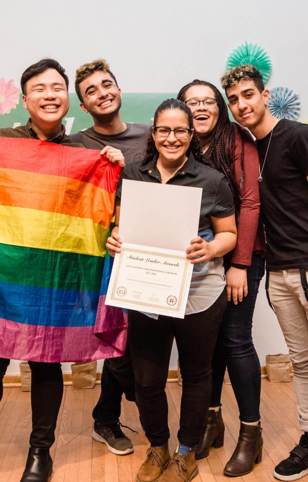 student members of ostem holding a rainbow pride flag