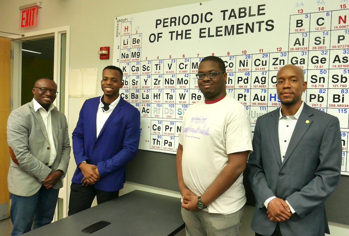 black male students standing in front of periodic table