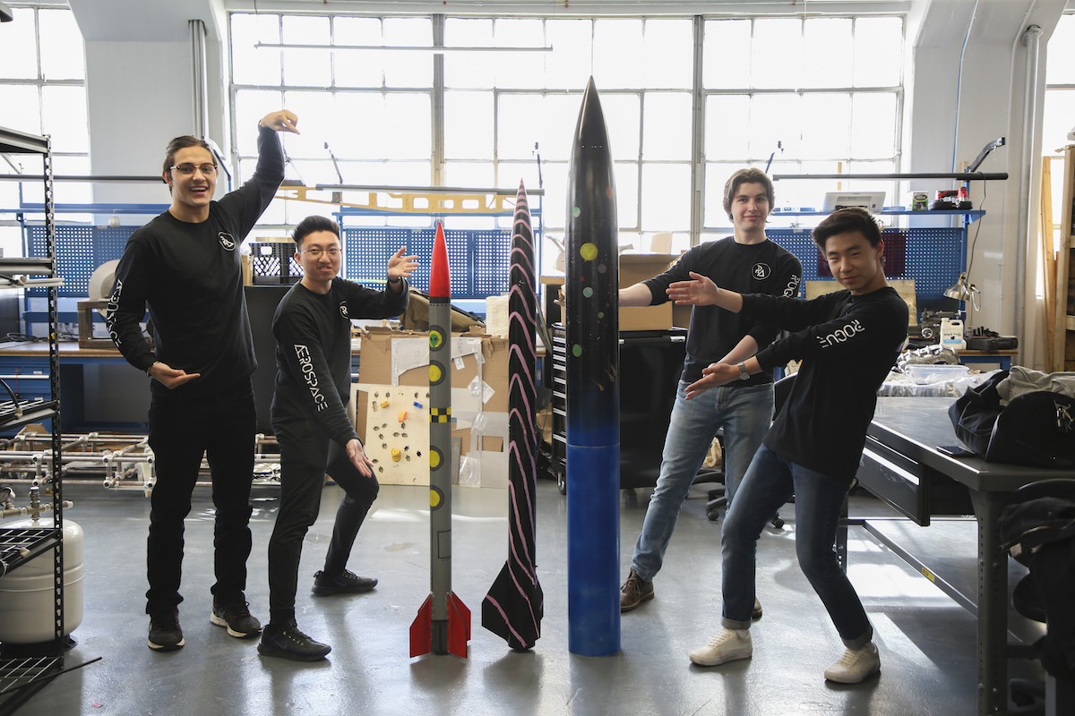 students posing around rockets made in the makergarage